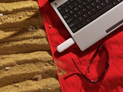 laptop, eyeglass and sand